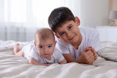 Photo of Cute little brothers on bed at home