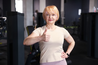 Photo of Senior woman showing thumbs up in gym