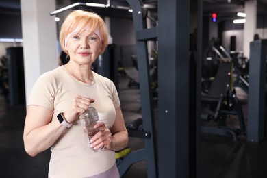 Photo of Senior woman with bottle of water in gym
