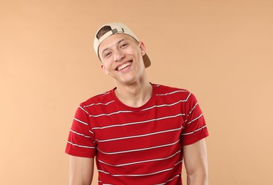 Photo of Young man in stylish baseball hat on beige background