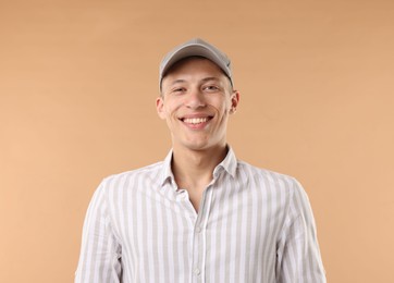 Photo of Young man in stylish baseball hat on beige background