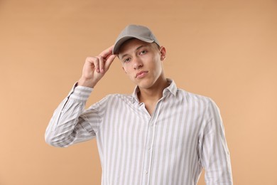 Photo of Young man in stylish baseball hat on beige background