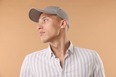 Photo of Young man in stylish baseball hat on beige background