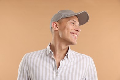 Photo of Young man in stylish baseball hat on beige background