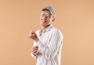 Photo of Young man in stylish baseball hat on beige background