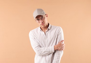 Photo of Young man in stylish baseball hat on beige background