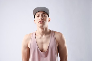 Photo of Young man in stylish baseball hat on light grey background