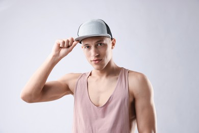 Photo of Young man in stylish baseball hat on light grey background
