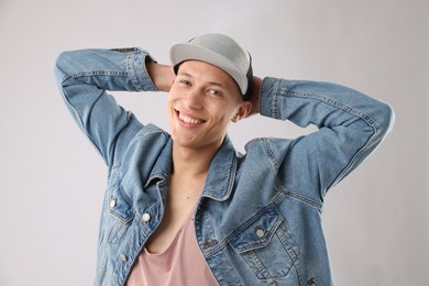 Photo of Young man in stylish baseball hat on light grey background