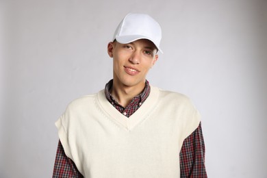 Photo of Young man in stylish baseball hat on light grey background