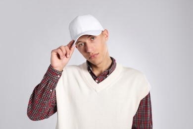 Photo of Young man in stylish baseball hat on light grey background
