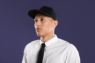 Photo of Young man in stylish baseball hat on dark blue background