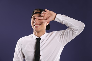Photo of Young man in stylish baseball hat on dark blue background