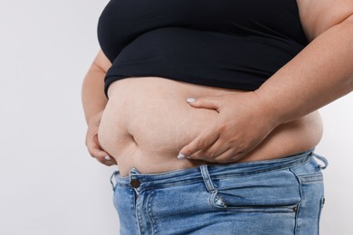 Photo of Woman with excessive belly fat on white background, closeup
