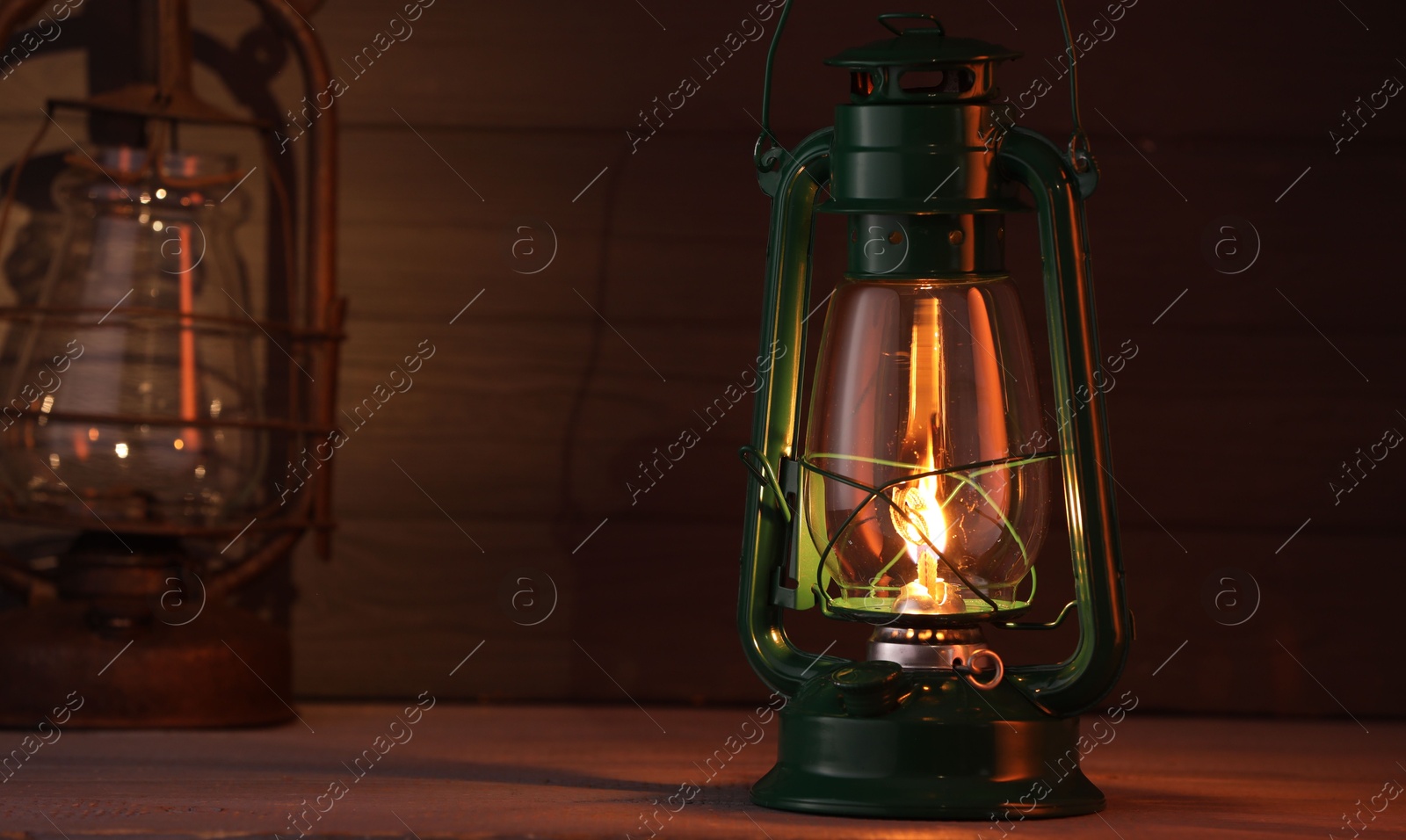 Vintage kerosene metal lamps on wooden table Photo of Vintage kerosene metal lamps on wooden table
