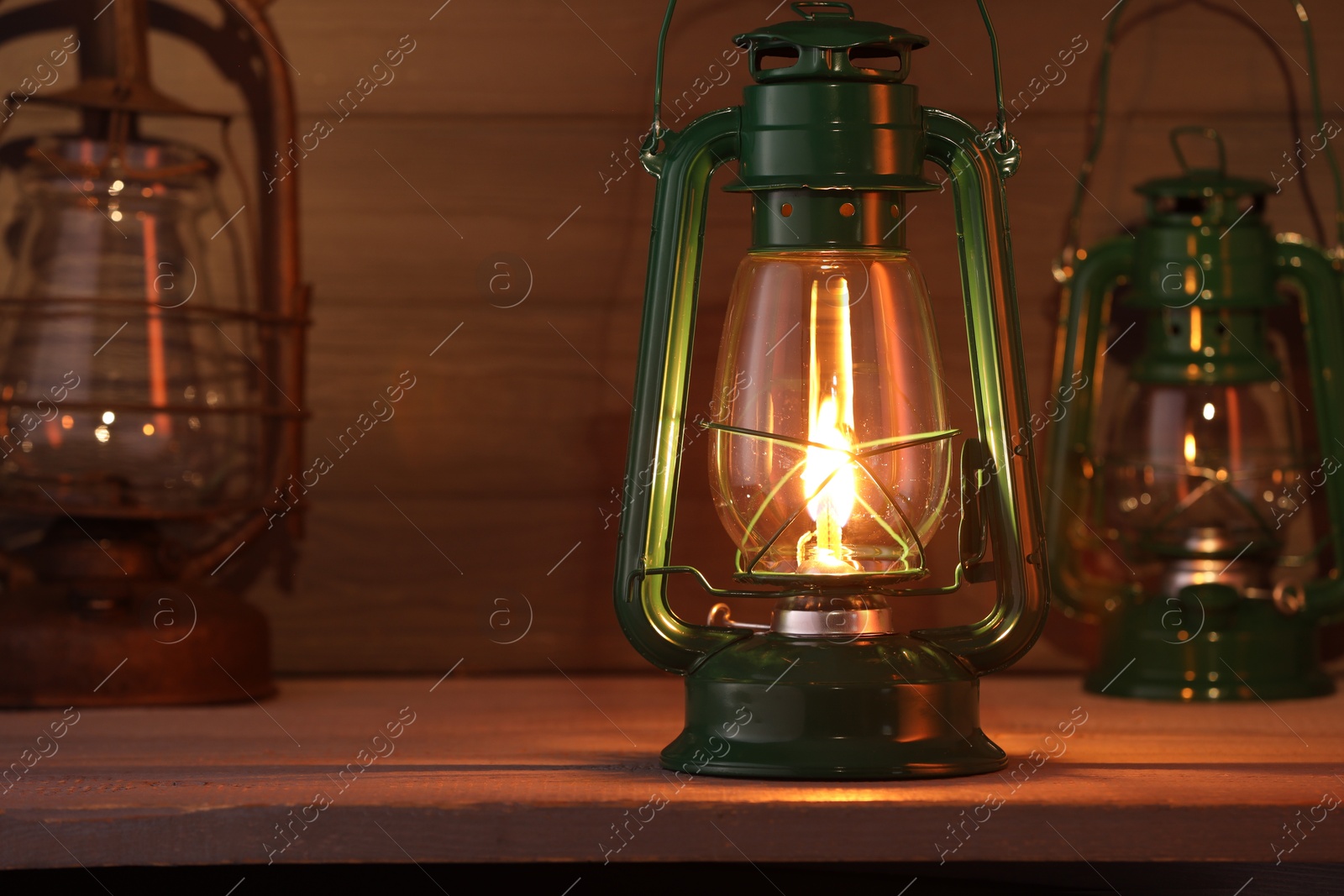 Vintage kerosene metal lamps on wooden table Photo of Vintage kerosene metal lamps on wooden table