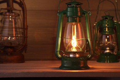 Photo of Vintage kerosene metal lamps on wooden table