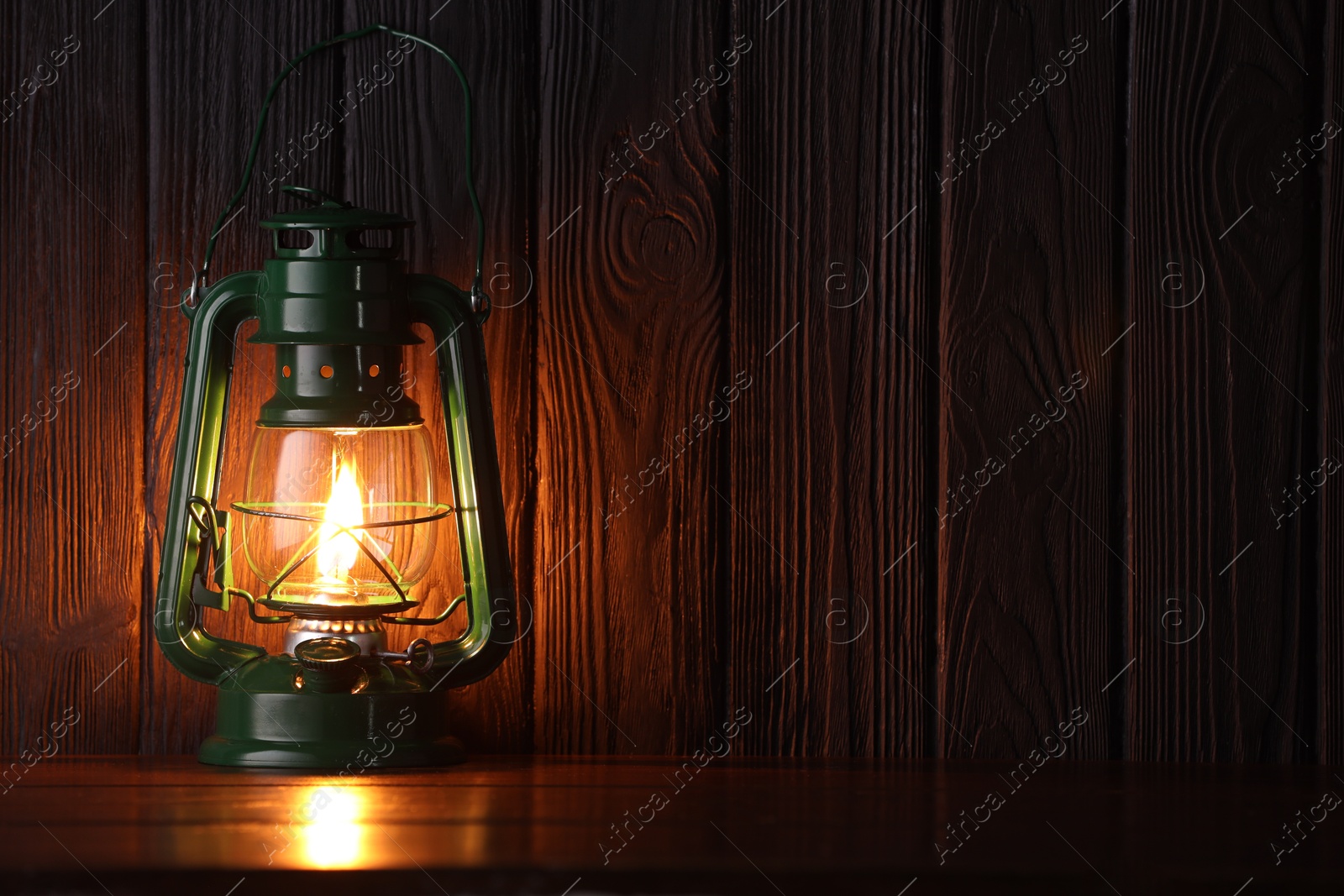 Vintage kerosene lamp on wooden table. Space for text Photo of Vintage kerosene lamp on wooden table. Space for text