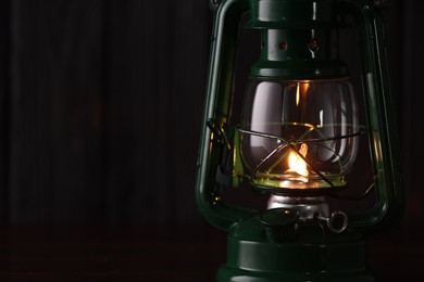 Photo of Vintage kerosene lamp on wooden table, closeup. Space for text