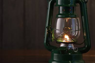 Photo of Vintage kerosene lamp on wooden table, closeup. Space for text