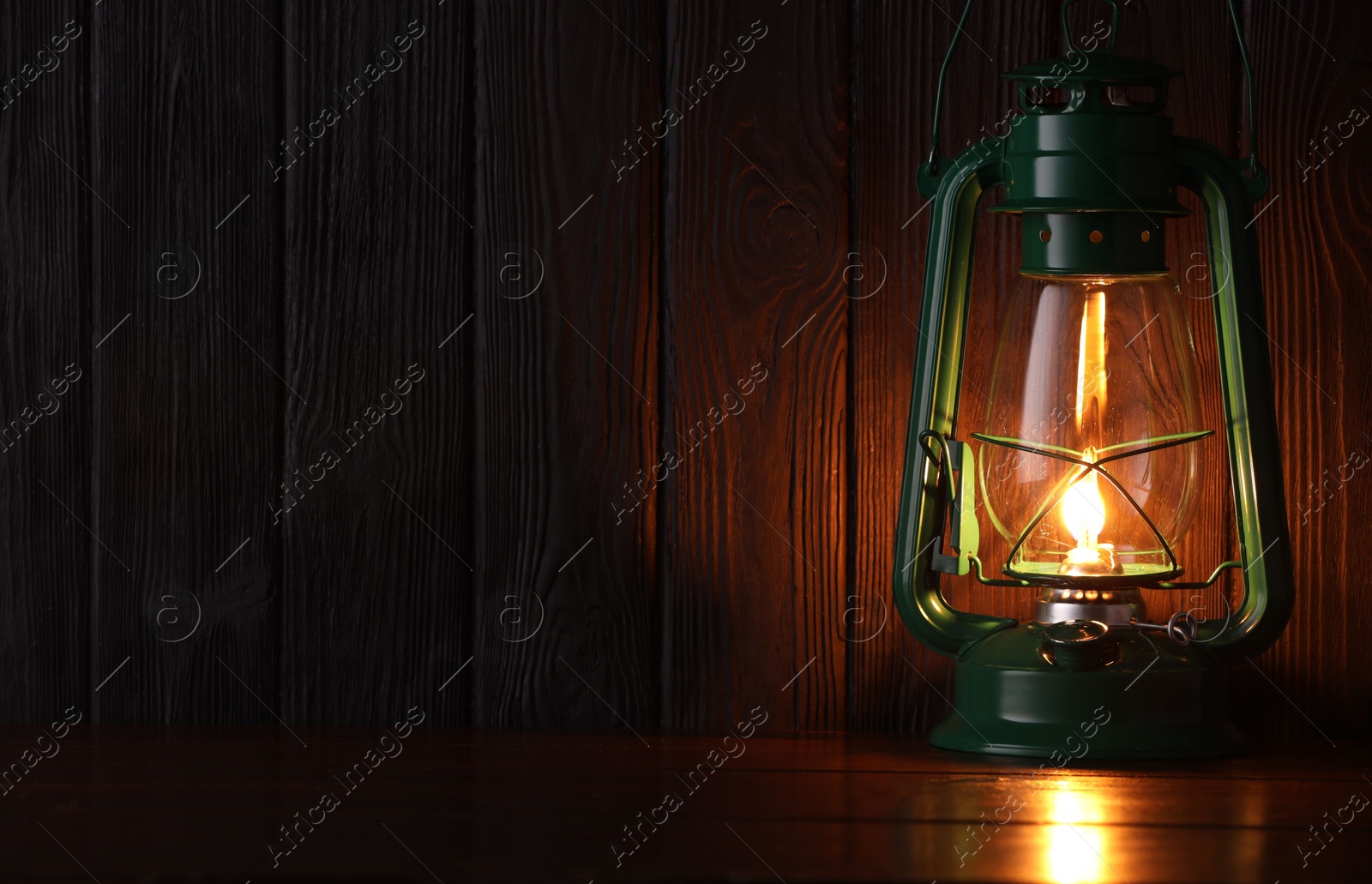 Vintage kerosene lamp on wooden table. Space for text Photo of Vintage kerosene lamp on wooden table. Space for text