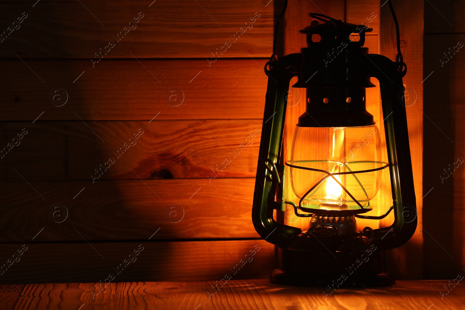 Vintage kerosene lamp on wooden table. Space for text Photo of Vintage kerosene lamp on wooden table. Space for text