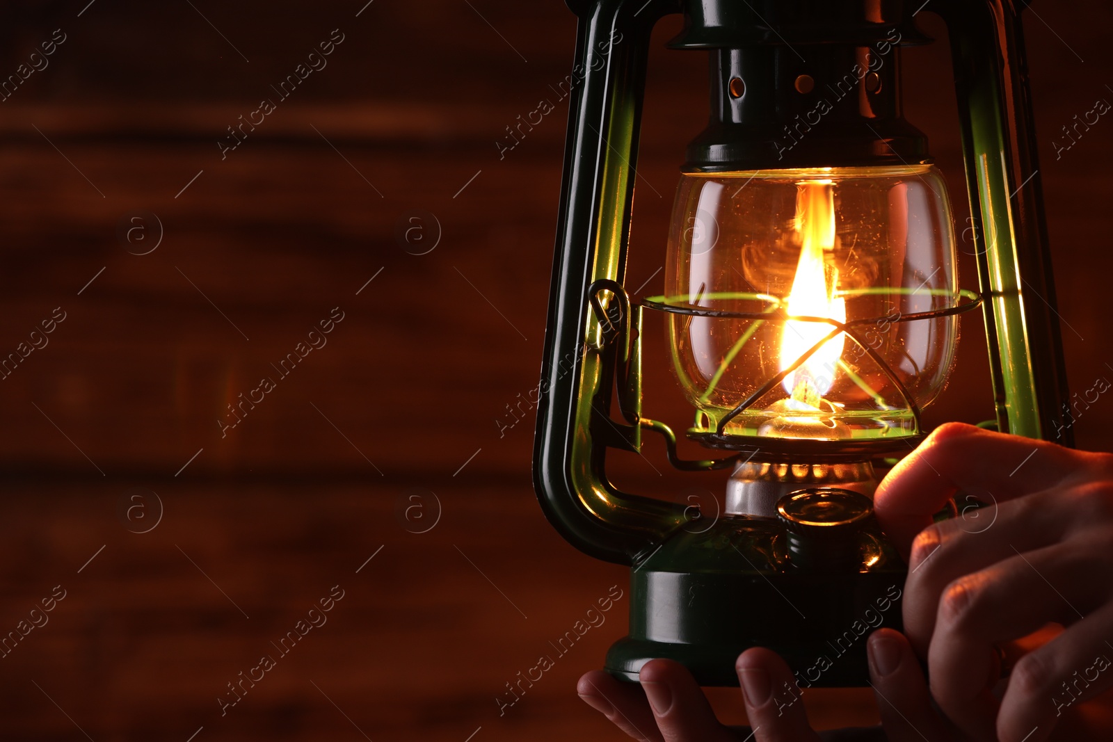 Man with vintage kerosene lamp on wooden background, closeup. Space for text Photo of Man with vintage kerosene lamp on wooden background, closeup. Space for text