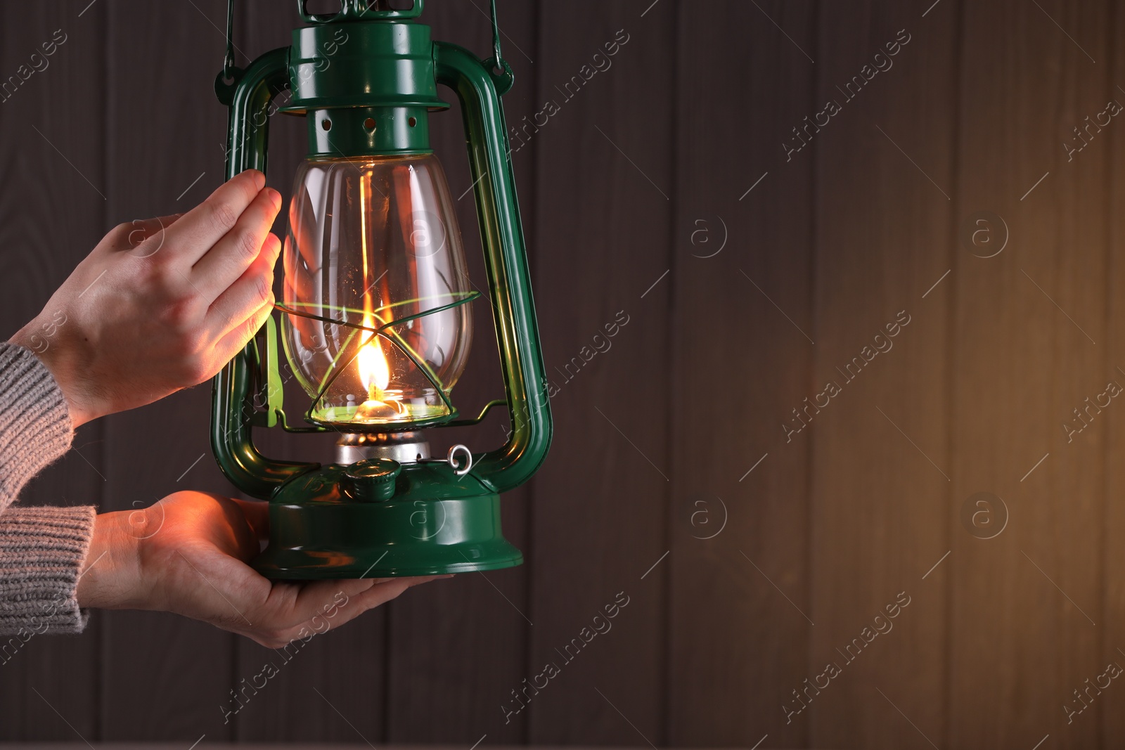 Man with vintage kerosene lamp on wooden background, closeup. Space for text Photo of Man with vintage kerosene lamp on wooden background, closeup. Space for text