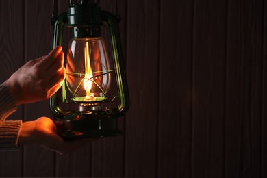 Photo of Man with vintage kerosene lamp on wooden background, closeup. Space for text