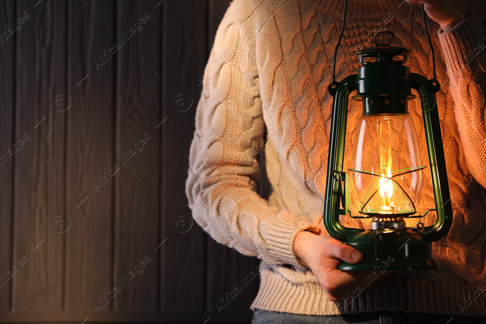Man with vintage kerosene lamp on wooden background, closeup. Space for text Photo of Man with vintage kerosene lamp on wooden background, closeup. Space for text
