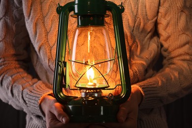 Photo of Man with vintage kerosene lamp on wooden background, closeup
