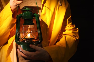 Photo of Man with vintage kerosene lamp on wooden background, closeup