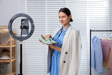 Photo of Professional stylist having online consultation with client via smartphone indoors