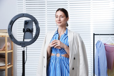 Photo of Professional stylist having online consultation with client via smartphone indoors