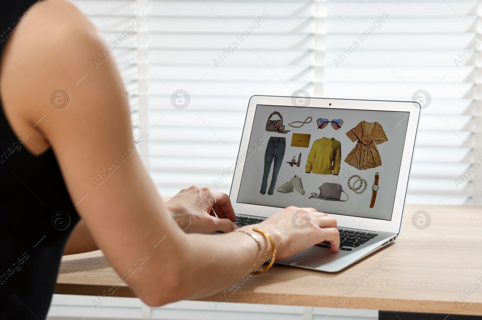 Professional stylist making collage with outfit on laptop at desk indoors, closeup Photo of Professional stylist making collage with outfit on laptop at desk indoors, closeup