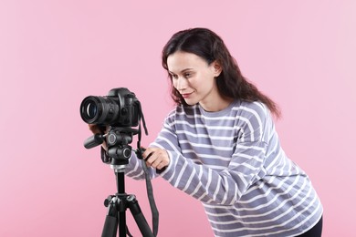 Photo of Woman with professional video camera on pink background