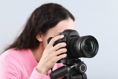 Photo of Woman with professional video camera on light grey background