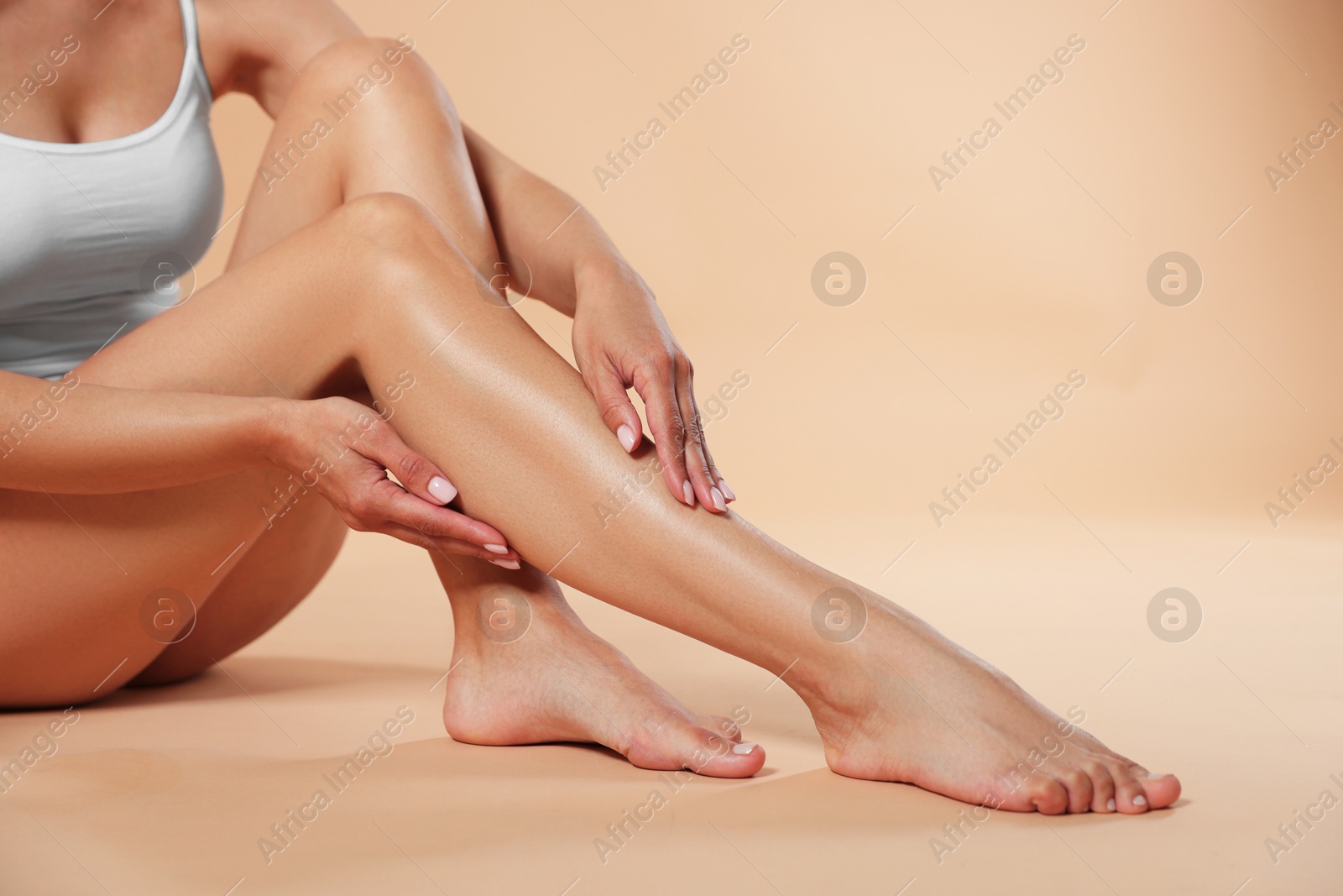 Woman with beautiful smooth legs after epilation on beige background, closeup. Space for text Photo of Woman with beautiful smooth legs after epilation on beige background, closeup. Space for text