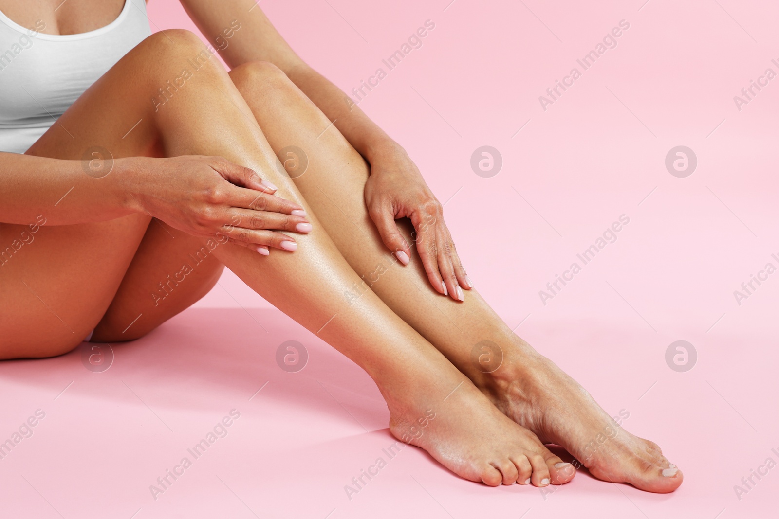 Woman with beautiful smooth legs after epilation on pink background, closeup. Space for text Photo of Woman with beautiful smooth legs after epilation on pink background, closeup. Space for text