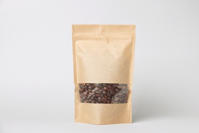 Photo of One zipper stand-up pouch with coffee beans on white background. Mockup for design