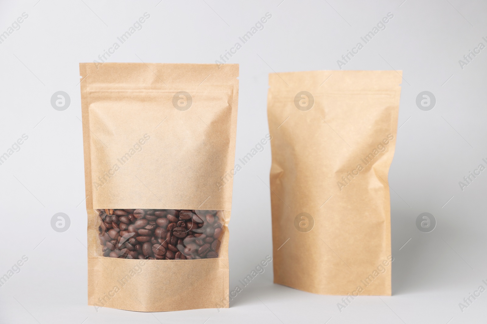 Zipper stand-up pouches with coffee beans on white background. Mockup for design Photo of Zipper stand-up pouches with coffee beans on white background. Mockup for design