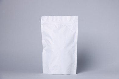 Photo of One zipper stand-up pouch on light grey background. Mockup for design