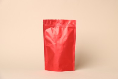 Photo of One zipper stand-up pouch on beige background. Mockup for design