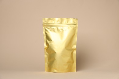 Photo of One zipper stand-up pouch on beige background. Mockup for design