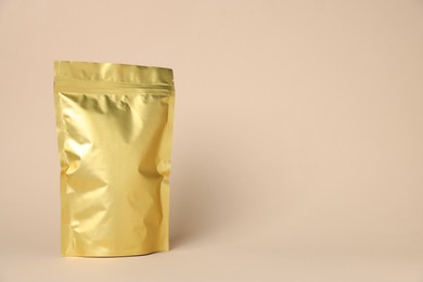 Photo of One zipper stand-up pouch on beige background. Mockup for design