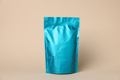 Photo of One zipper stand-up pouch on beige background. Mockup for design