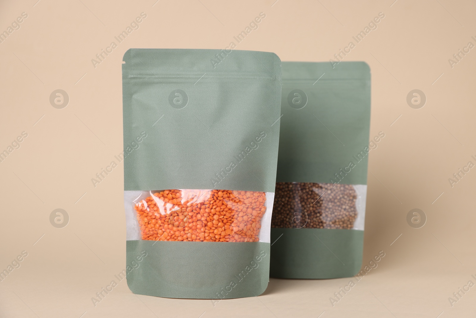 Zipper stand-up pouches with lentils and seeds on beige background. Mockup for design Photo of Zipper stand-up pouches with lentils and seeds on beige background. Mockup for design