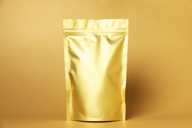 Photo of One zipper stand-up pouch on light orange background. Mockup for design