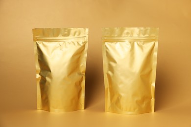 Photo of Zipper stand-up pouches on light orange background. Mockup for design
