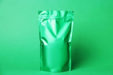 Photo of One zipper stand-up pouch on green background. Mockup for design